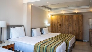 A hotel room with a large bed, two bedside tables, a wooden wardrobe, and a ceiling with recessed lighting. - Velaris Boutique Hotel (Serik)