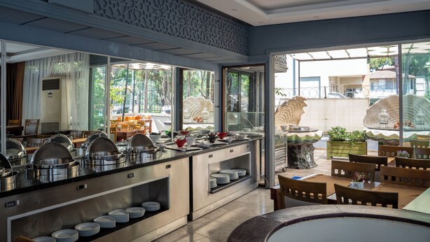 A buffet setup with various food containers and serving dishes. - Velaris Boutique Hotel (Serik)