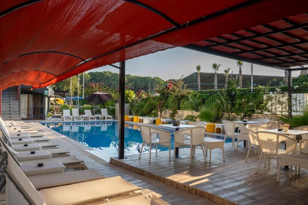 A poolside area with lounge chairs, a pool, and outdoor seating.