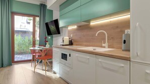 A modern kitchen with white cabinets, a wooden countertop, and a built-in oven. - Granaria A105 | Terrace | Perfect for Couples (Gdańsk)