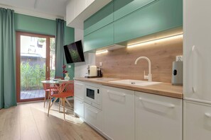 Eine moderne Küche mit weißen Schränken, einer Holzarbeitsplatte und einem eingebauten Backofen.