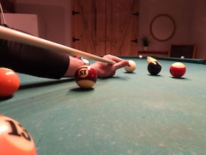 A pool table with balls and a cue stick. - The Little Alpine - Spa & Mountain (Petite-Rivière-Saint-François)