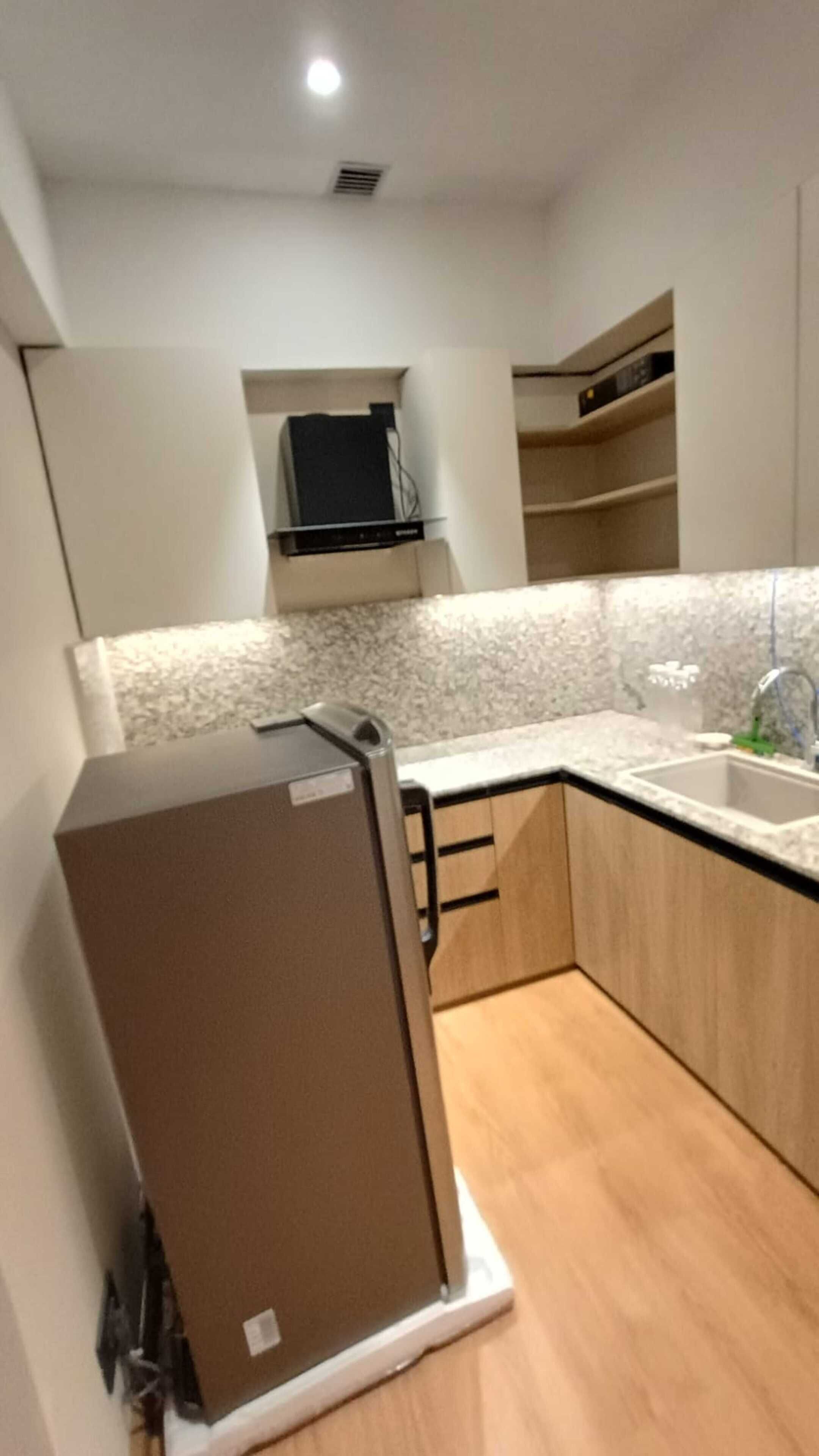 Una cocina compacta con refrigerador integrado, pileta y microondas.
