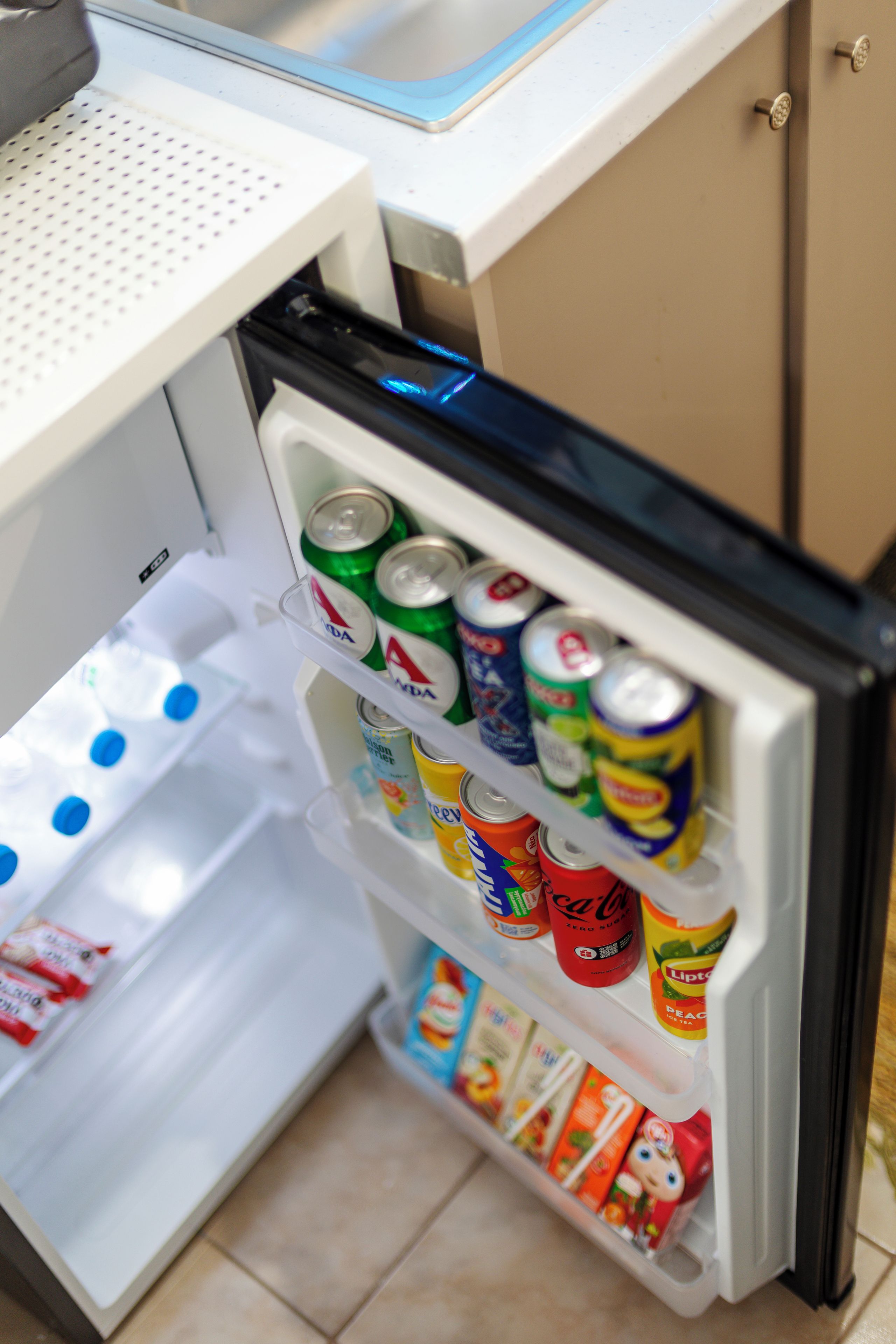 A refrigerator stocked with various beverages and snacks.