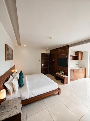 Une chambre d’hôtel moderne équipée d’un lit, d’un bureau, d’une télévision et d’une armoire.