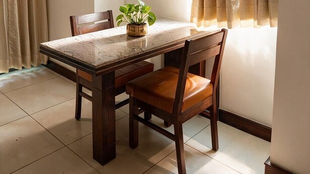 A dining area with a table, chairs, a potted plant, and a window with curtains. - Hotel Oasis One (Gurugram)