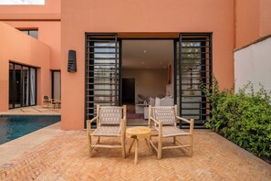A poolside area with two wicker chairs and a small round table. - Riad Safran Al Maaden Golf – Marrakech (Marrakech)