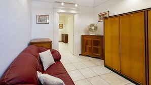 A room with a red sofa, wooden cabinet, and a wardrobe. - An elegant 62 sqm flat, ideal for three people, located on the ground floor of an Art Nouveau villa.The property enjoys a strategic location just a short distance from Pescara city center.The hospital is within a 5-minute walk, while the seaside is a 5-m (Pescara)