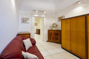 A room with a red sofa, wooden cabinet, and a wardrobe. - An elegant 62 sqm flat, ideal for three people, located on the ground floor of an Art Nouveau villa.The property enjoys a strategic location just a short distance from Pescara city center.The hospital is within a 5-minute walk, while the seaside is a 5-m (Pescara)