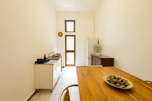 A compact kitchen with a dining table, a refrigerator, and a sink. - An elegant 62 sqm flat, ideal for three people, located on the ground floor of an Art Nouveau villa.The property enjoys a strategic location just a short distance from Pescara city center.The hospital is within a 5-minute walk, while the seaside is a 5-m (Pescara)