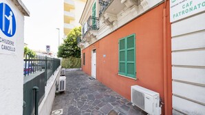 A narrow alley with a stone pavement, a white building with green shutters, and a sign indicating a parking area. - An elegant 62 sqm flat, ideal for three people, located on the ground floor of an Art Nouveau villa.The property enjoys a strategic location just a short distance from Pescara city center.The hospital is within a 5-minute walk, while the seaside is a 5-m (Pescara)