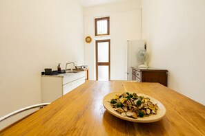 A room with a wooden dining table, a white cabinet, a small window, and a door. - An elegant 62 sqm flat, ideal for three people, located on the ground floor of an Art Nouveau villa.The property enjoys a strategic location just a short distance from Pescara city center.The hospital is within a 5-minute walk, while the seaside is a 5-m (Pescara)