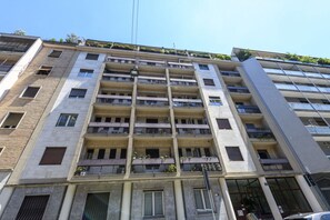Un edificio de varios pisos con balcones, ventanas grandes y fachada plana.