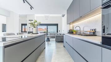 A modern kitchen with a central island, built-in appliances, and a dining area with a sofa and coffee table.