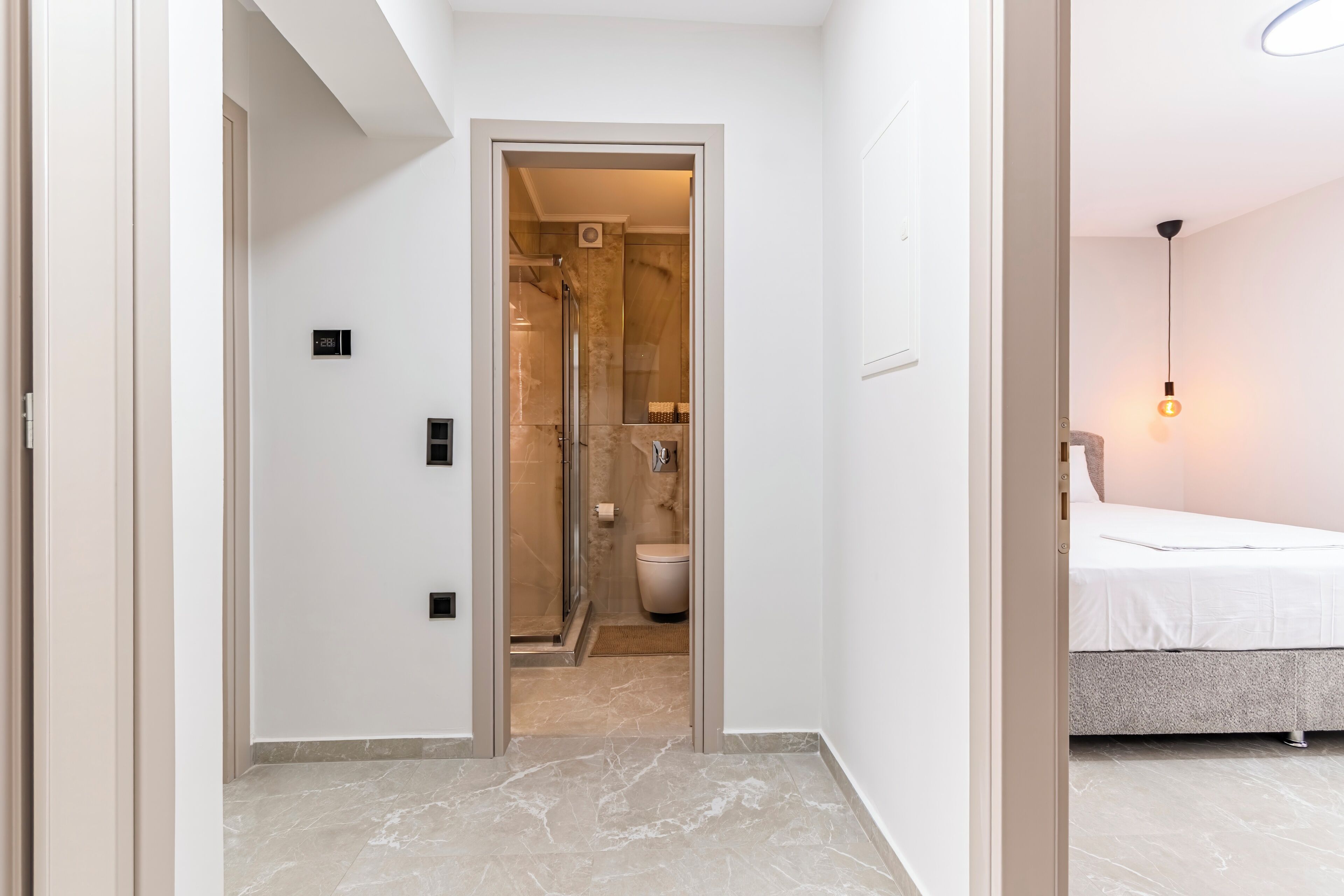 A modern bathroom with a glass shower enclosure, a toilet, and a sink.