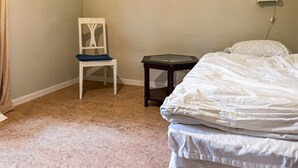 A bedroom with a bed, a chair, a small table, and a wall-mounted power outlet. - 3 bedroom stunning home in Linköping (Linköping)