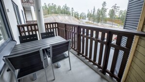 A balcony with a table and chairs, a view of a construction site, and a wooden fence. - Ruka Ski Chalets (60m²) with balcony and WiFi (Kuusamo)