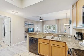 A modern kitchen with granite countertops, stainless steel appliances, and a built-in dishwasher. - 3111 Poolside Villa, Family Fun ~ Book Oct 22nd ~ Pools Bar Gym Dining Hot Tub (Destin)