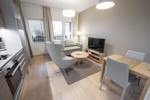 A modern kitchen with a stove, oven, and a dining area with a table and chairs.