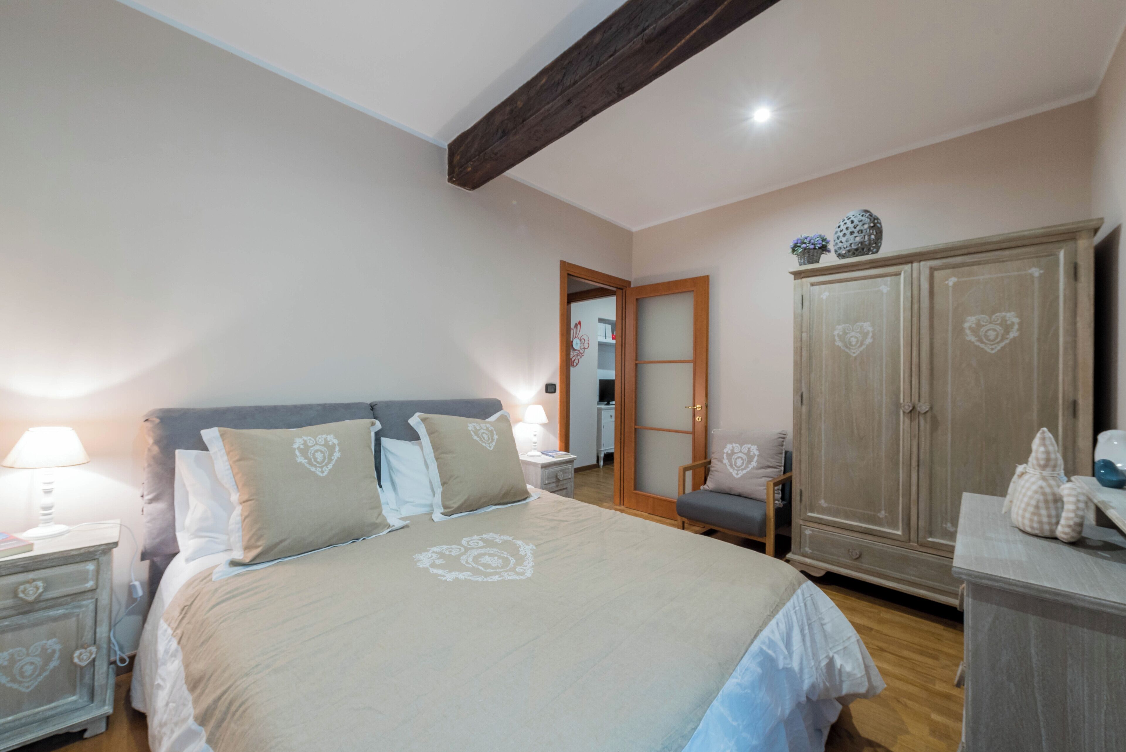 Une chambre à coucher avec un grand lit, une armoire, une table de chevet et une commode.
