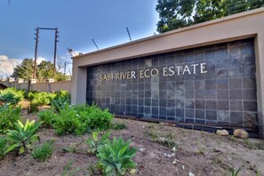 En grind med en skylt som lyder: ”SABI RIVER ECO ESTATE”.