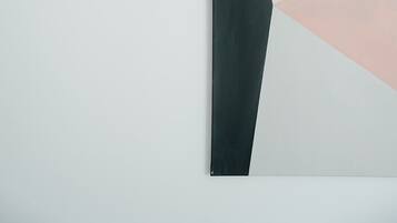 Una pintura abstracta geométrica con fondo claro y formas oscuras.