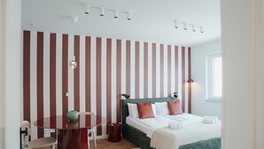 A bedroom with a bed, bedside table, and a chair.