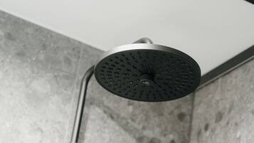 A showerhead with a circular design and a handheld shower attachment.