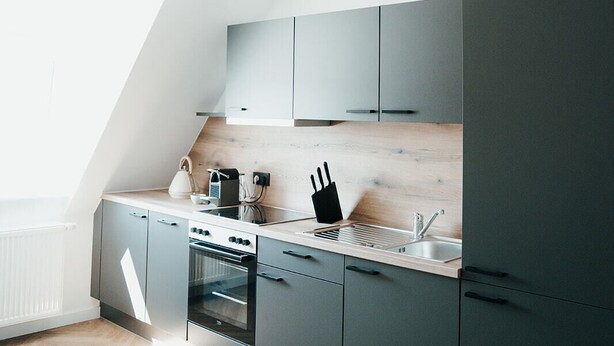 Una cocina moderna con horno empotrado, un lavabo y una encimera.