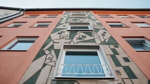 Fachada de edificio con patrones geométricos y varias ventanas.
