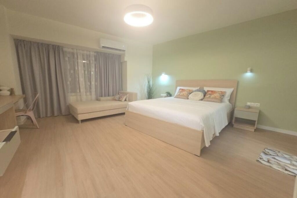 Un dormitorio con cama, una silla, una mesita de noche y un tocador.