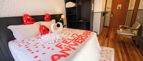A hotel room with a bed, a wardrobe, a desk, and a chair.