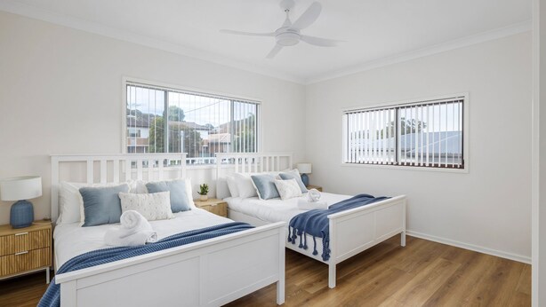 A hotel room with two beds, a ceiling fan, and large windows. - 'Sopra'  Shoal Bay - Close to the beach (Shoal Bay)