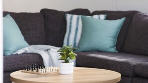 A round wooden coffee table with a chess set and a potted plant in the center. - 'Sopra'  Shoal Bay - Close to the beach (Shoal Bay)