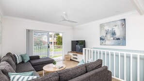 A modern living room with a sofa set, a coffee table, a television, and a painting on the wall. - 'Sopra'  Shoal Bay - Close to the beach (Shoal Bay)