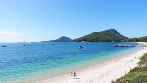 A beach with clear blue water, boats, and a mountain in the background. - 'Sopra'  Shoal Bay - Close to the beach (Shoal Bay)