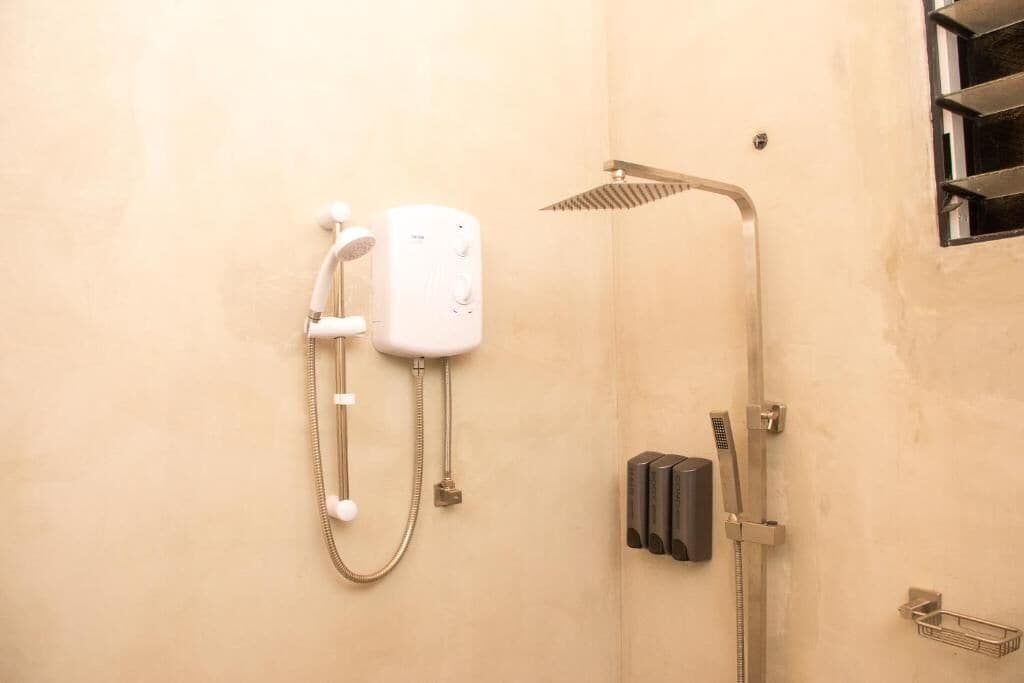 A shower area with a handheld showerhead and a wall-mounted showerhead.