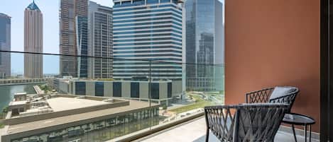 A balcony with a view of a cityscape, including high-rise buildings and a hotel named 'SELECT GROUP'.