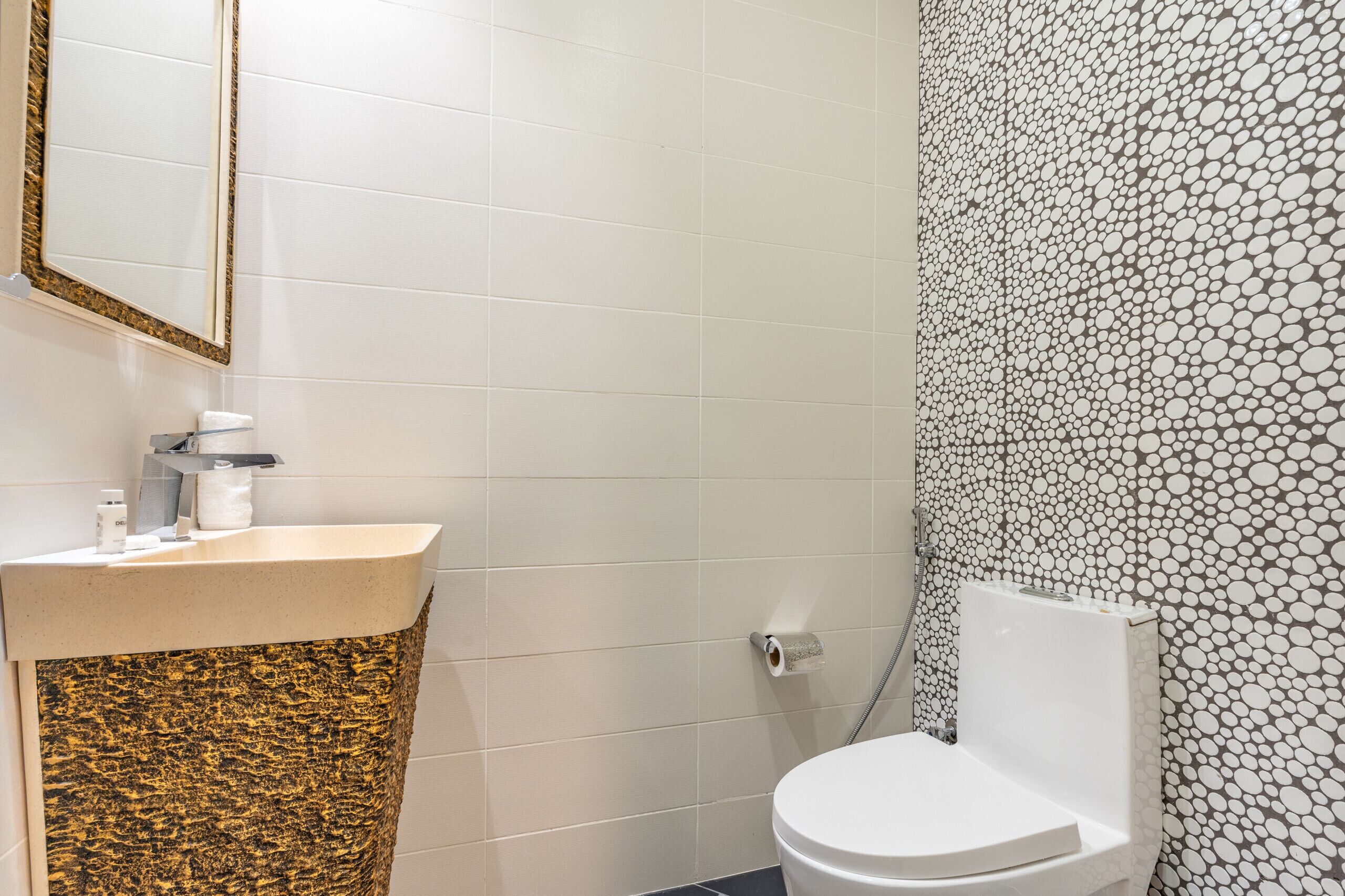Een badkamer met een witte wastafel, toilet en douche.