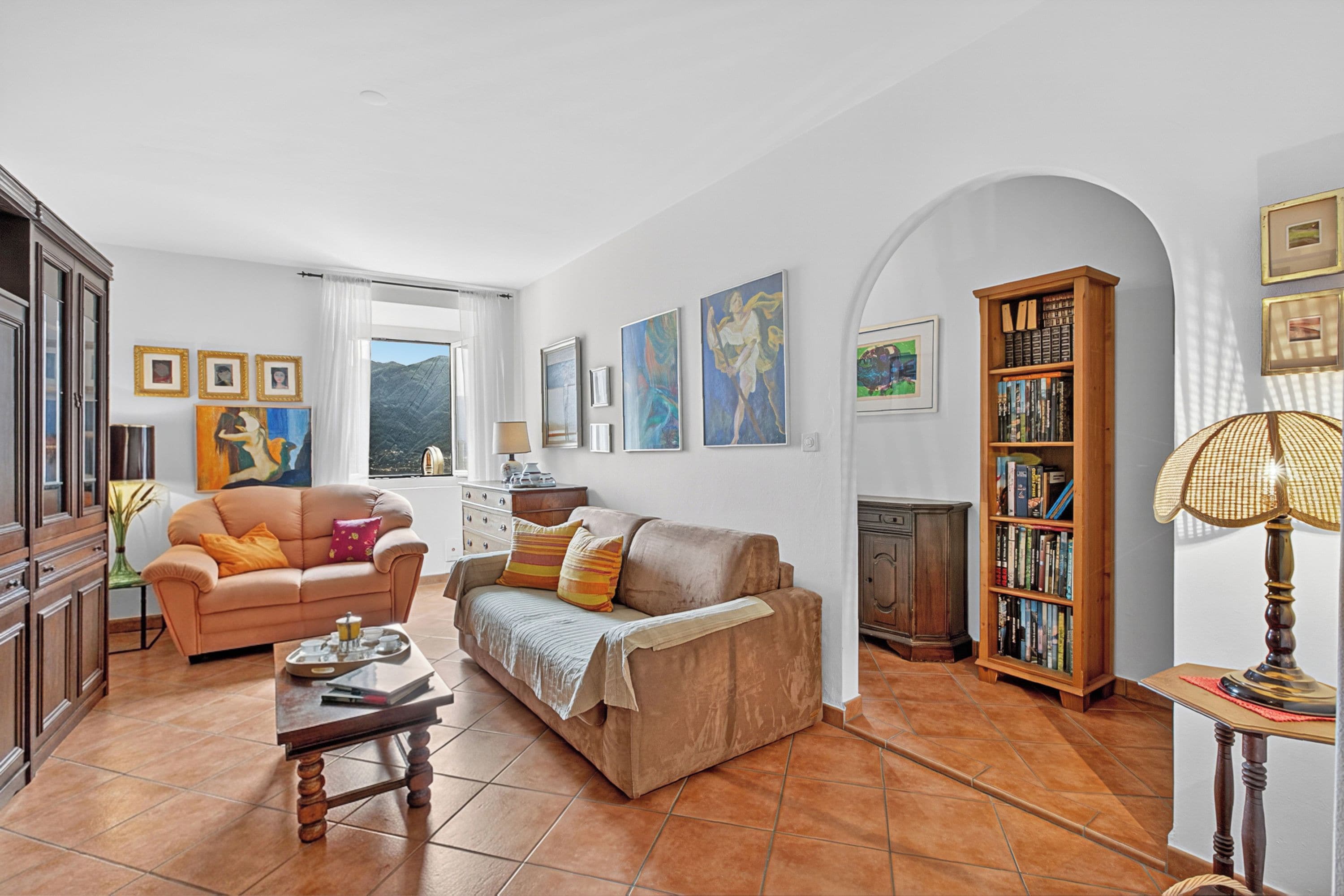 A living room with a sofa, coffee table, and bookshelf.