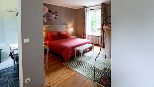 A bedroom with a bed, bedside table, and a window with curtains. - CLOS REMY (Précy-sur-Oise)