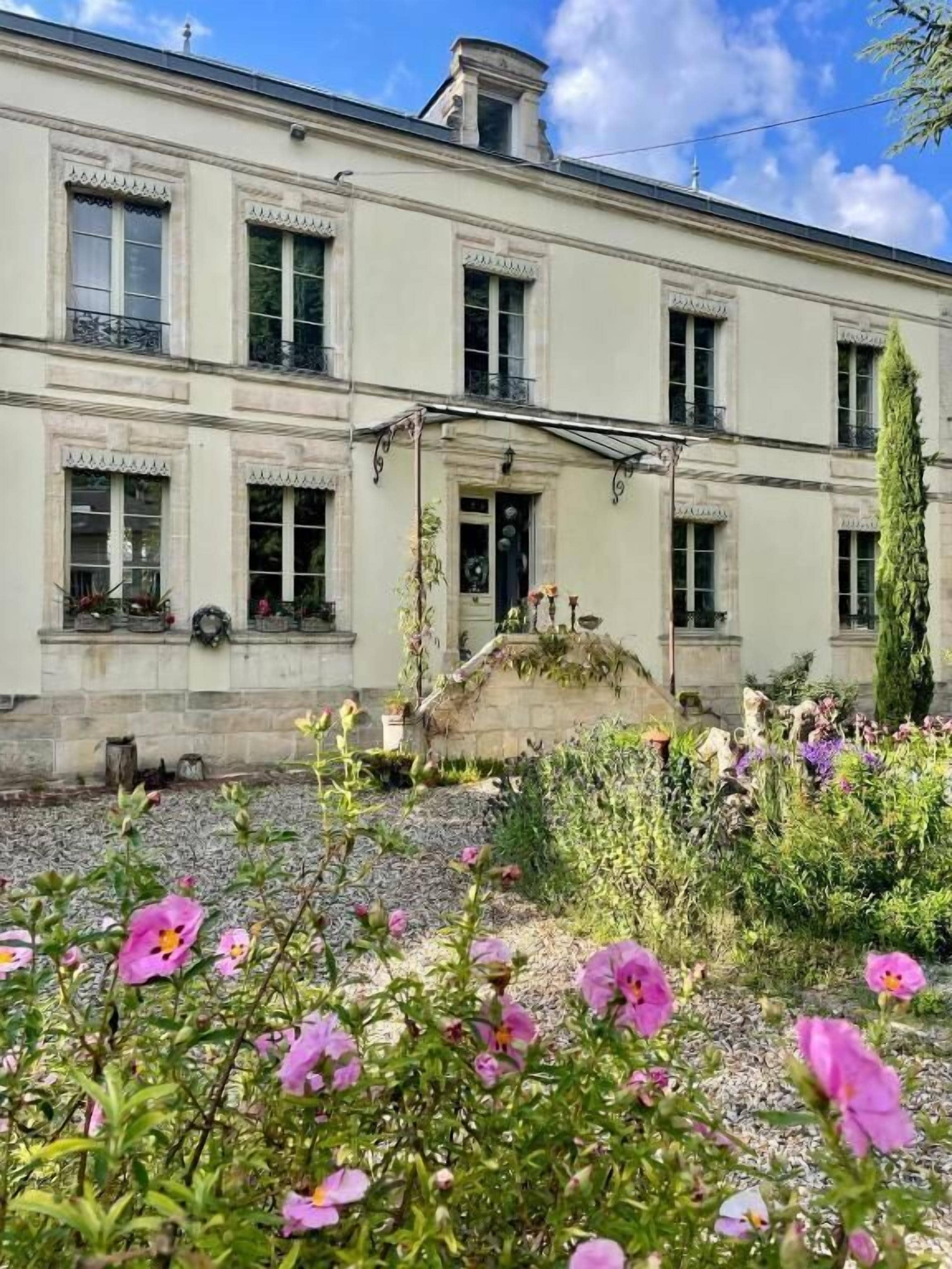 Un edificio de dos plantas con un jardín delantero.