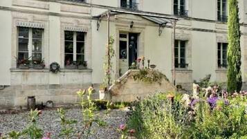 Un edificio de dos plantas con un jardín delantero.
