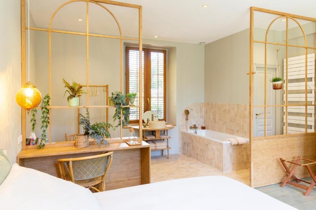 Une salle de bain moderne avec une baignoire, un lavabo et un miroir. On y trouve également des plantes et une lampe sur le meuble-lavabo.