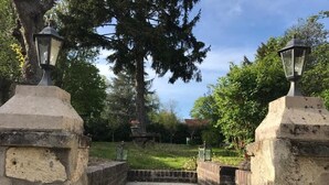 A stone pathway leading to a building entrance with steps and two lantern-style lights on either side. - CLOS REMY (Précy-sur-Oise)