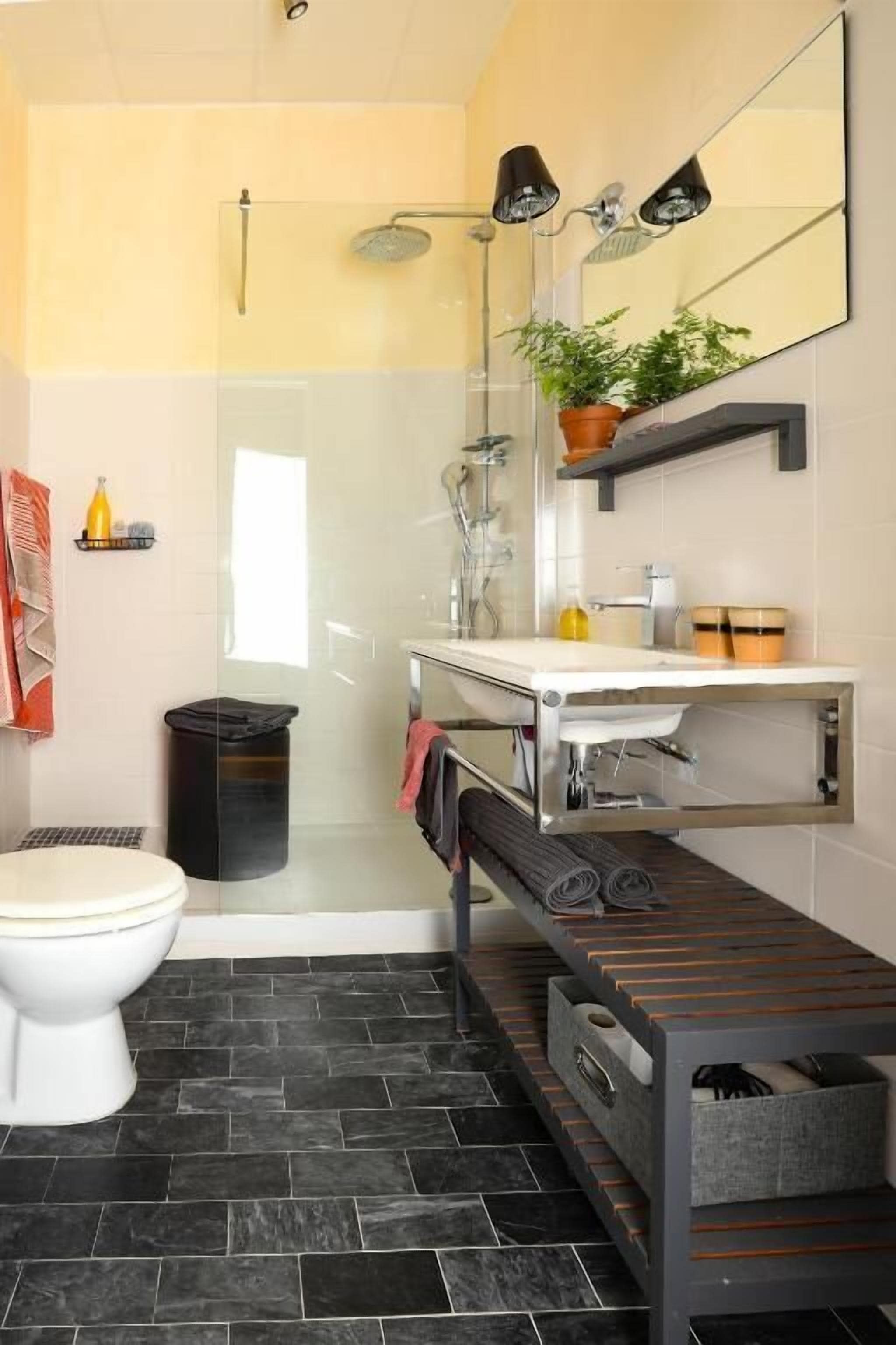 Une salle de bain équipée de toilettes, d’une douche et d’un lavabo.