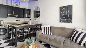 Ett kompakt bostadsutrymme med ett litet kök, en soffa och en matplats.