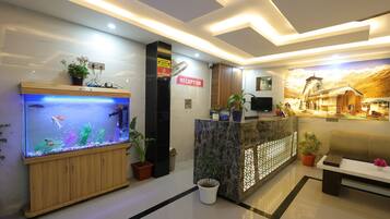 A reception area with a reception desk, a large aquarium, and a mural on the wall.