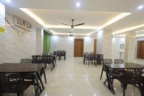 A conference room with marble walls, ceiling fans, and a tiled floor. - Hill View Haridwar Run by R.K. Group (Haridwar)