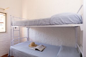 A bunk bed with a ladder, a hat, and a magazine on the lower bunk. - Istana Bay House by Wonderful Italy (Olbia)